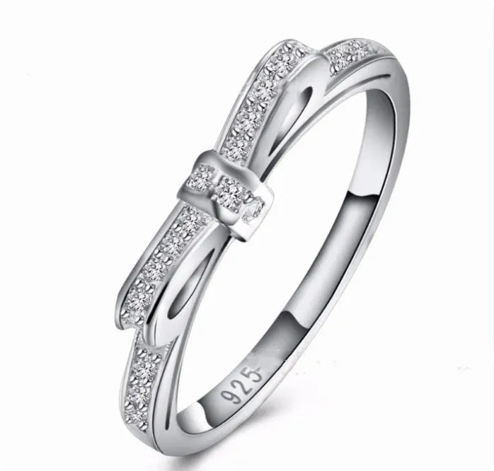 Silver bow-shaped ring with rhinestone and zircon crystal decoration on model hand