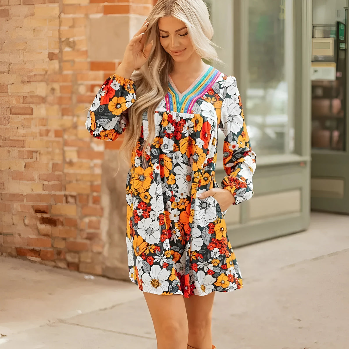 Orange floral stripe bodycon mini dress with V-neck and lace detailing on long sleeves.