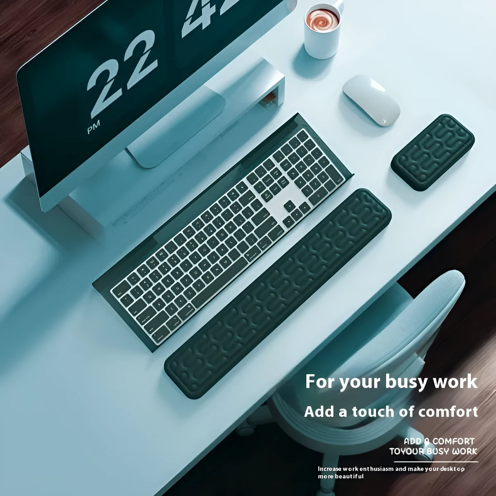 Double-sided black resin keyboard and mouse desk pad with integrated memory foam wrist rest.