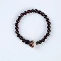 Rosewood bracelet with floral beads and circle pendant options on wooden background