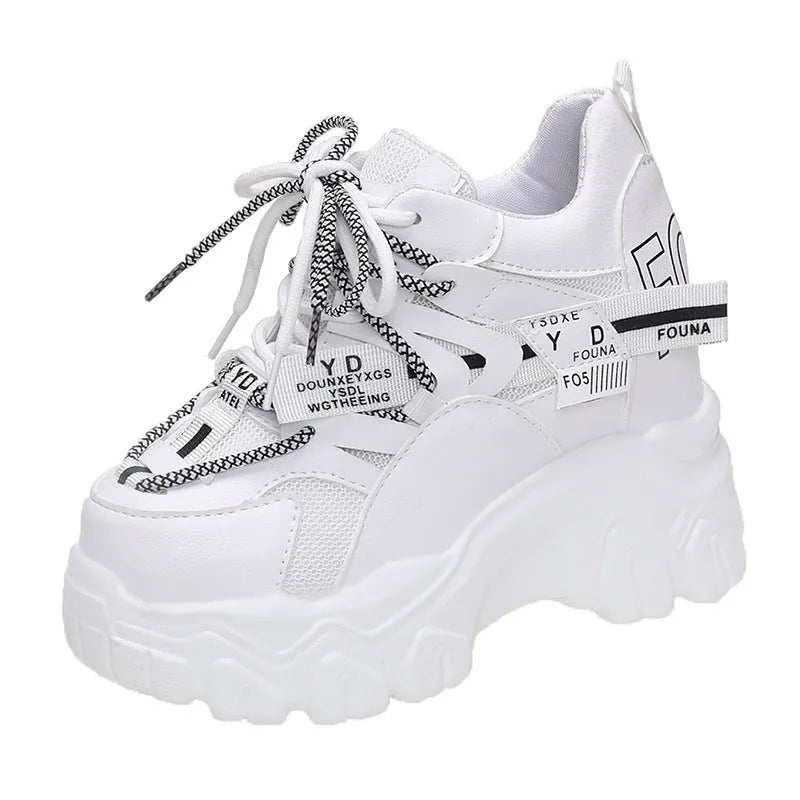 White women's low-top mesh sneakers with a black cross strap and a thick rubber platform sole.