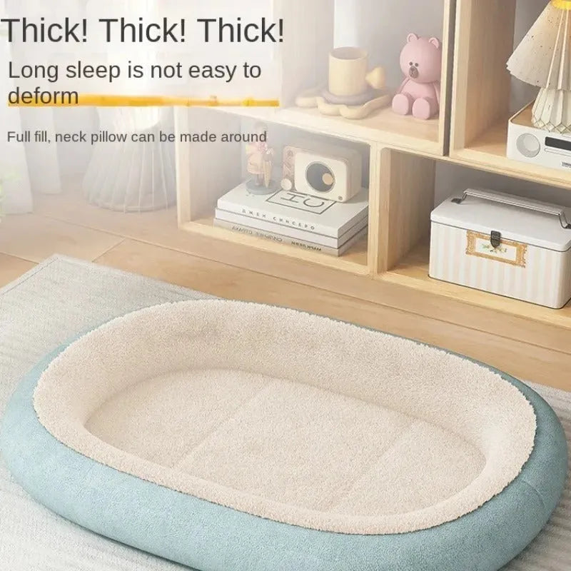 A grey thickened pet kennel with a fleece cover for a small dog resting inside on a wooden floor.
