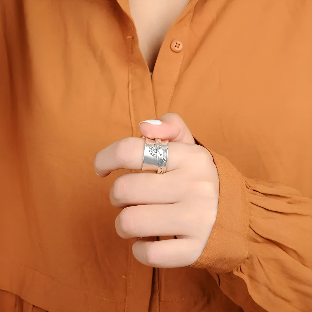 Silver rotatable flower ring showing floral detail and adjustable positioning