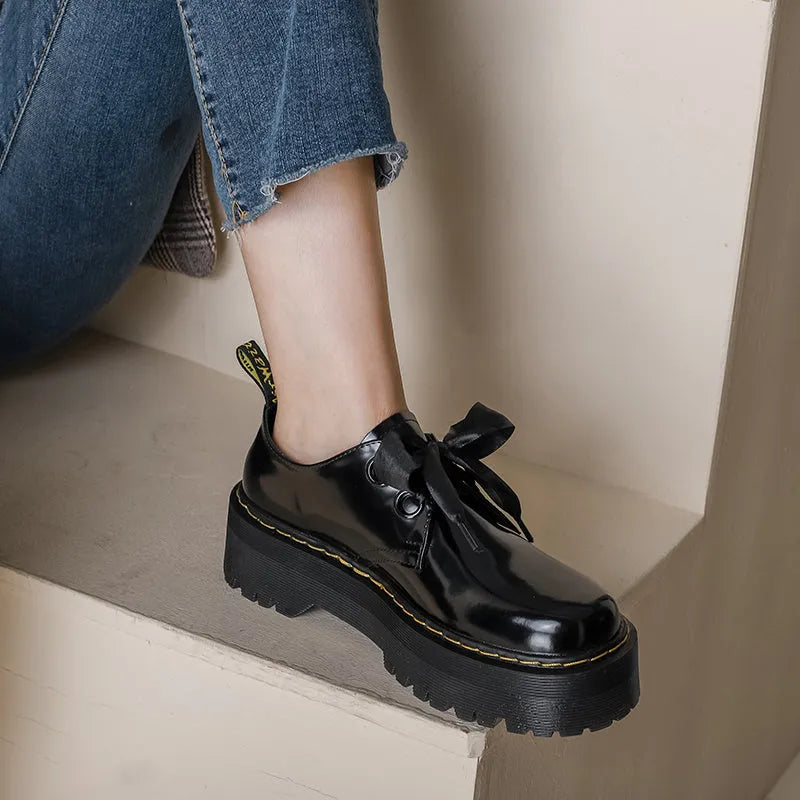 Women's black thick-soled lace-up shoes with white ribbon cross strap details on a superfine fibre upper.