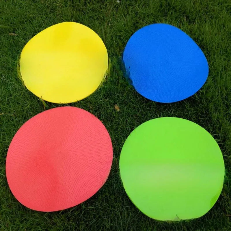 Yellow TPE football training marker disc lying flat on grass, 23cm diameter.