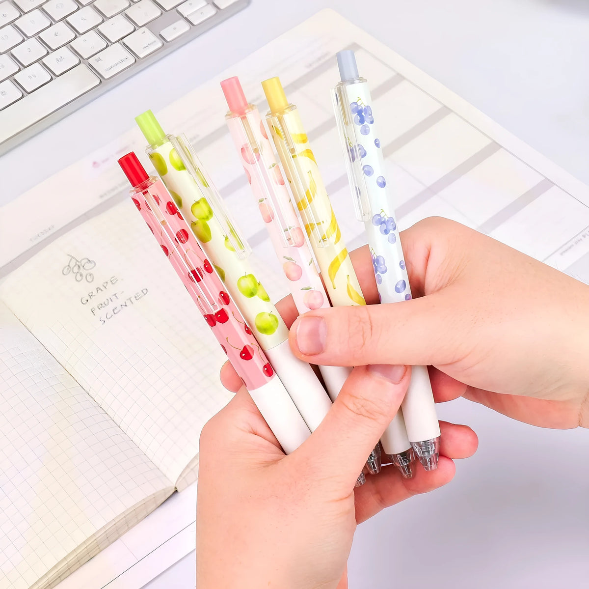 Three fruit-scented press-action pens with 0.5mm quick-drying black ink refills on writing paper