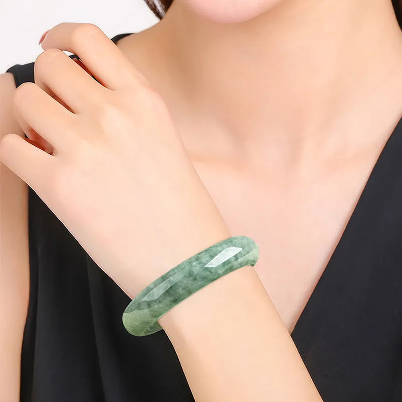 Women's natural emerald bean green ring bracelet on wrist, showing dark pea green beads and gift box.