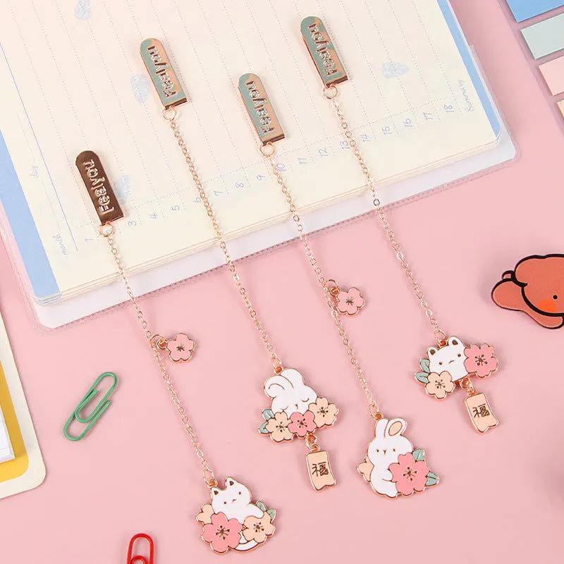 Small metal pendant bookmark with cartoon Sakura cat or cherry blossom rabbit illustration.
