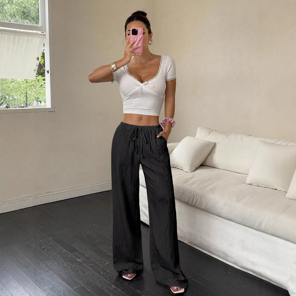 Women's black wide-leg trousers with lace-up waist trimming detail showing front view