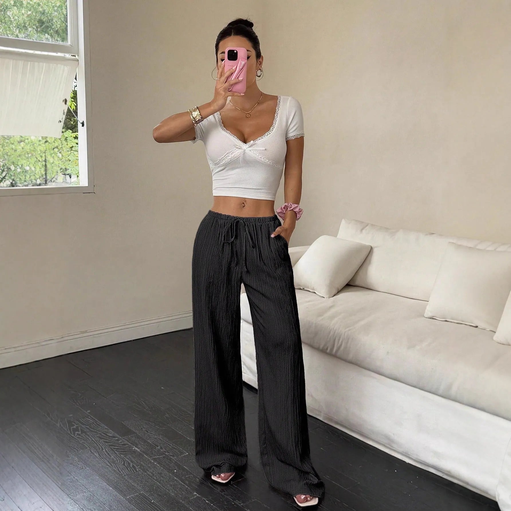 Women's black wide-leg trousers with lace-up waist trimming detail showing front view