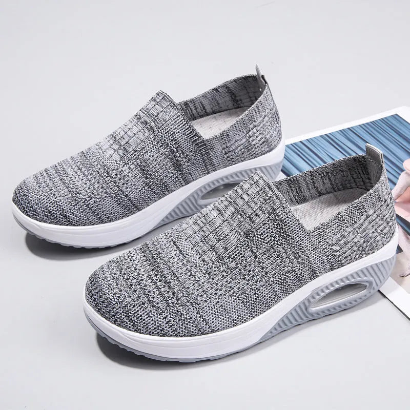Women's black mesh running shoes with air cushion sole and round toe on a grey background.