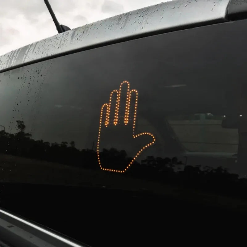 Black plastic LED gesture car light with remote control showing illuminated hand symbol.
