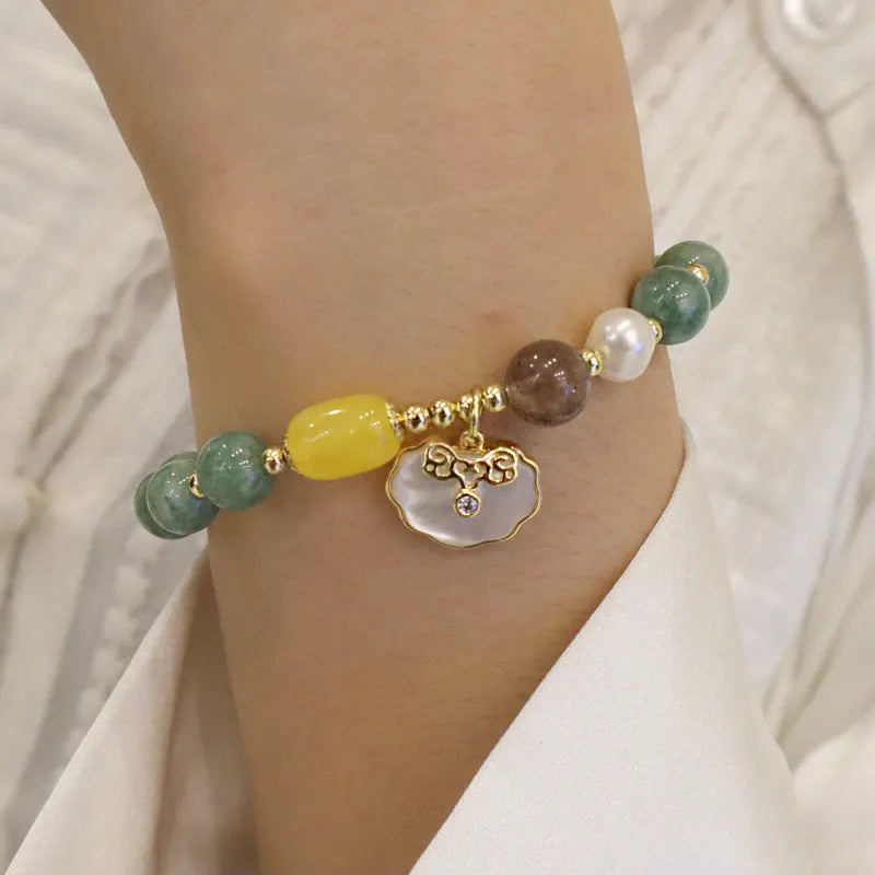 Green jade bracelet for women with a metal shell clasp on a wrist.