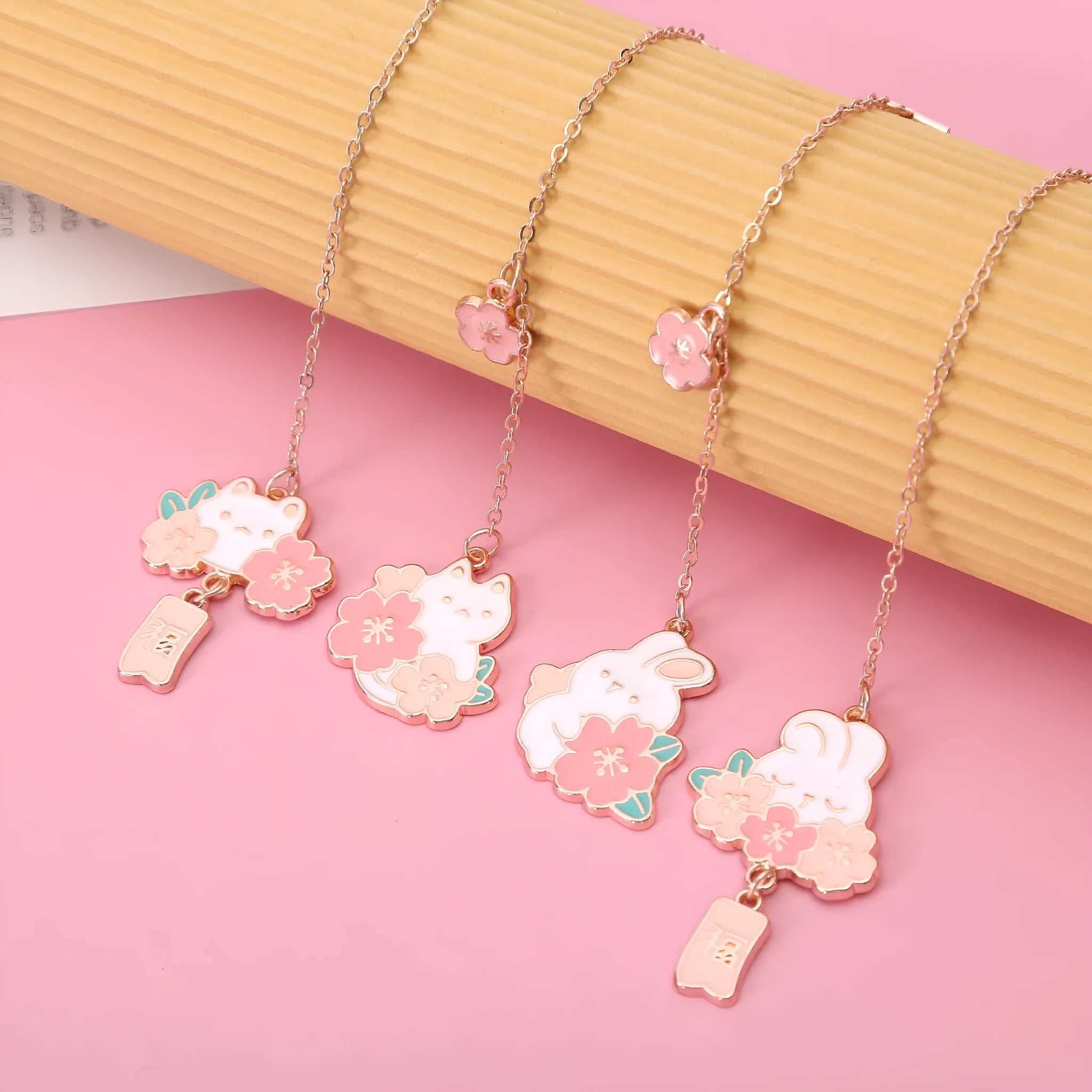 Small metal pendant bookmark with cartoon Sakura cat or cherry blossom rabbit illustration.