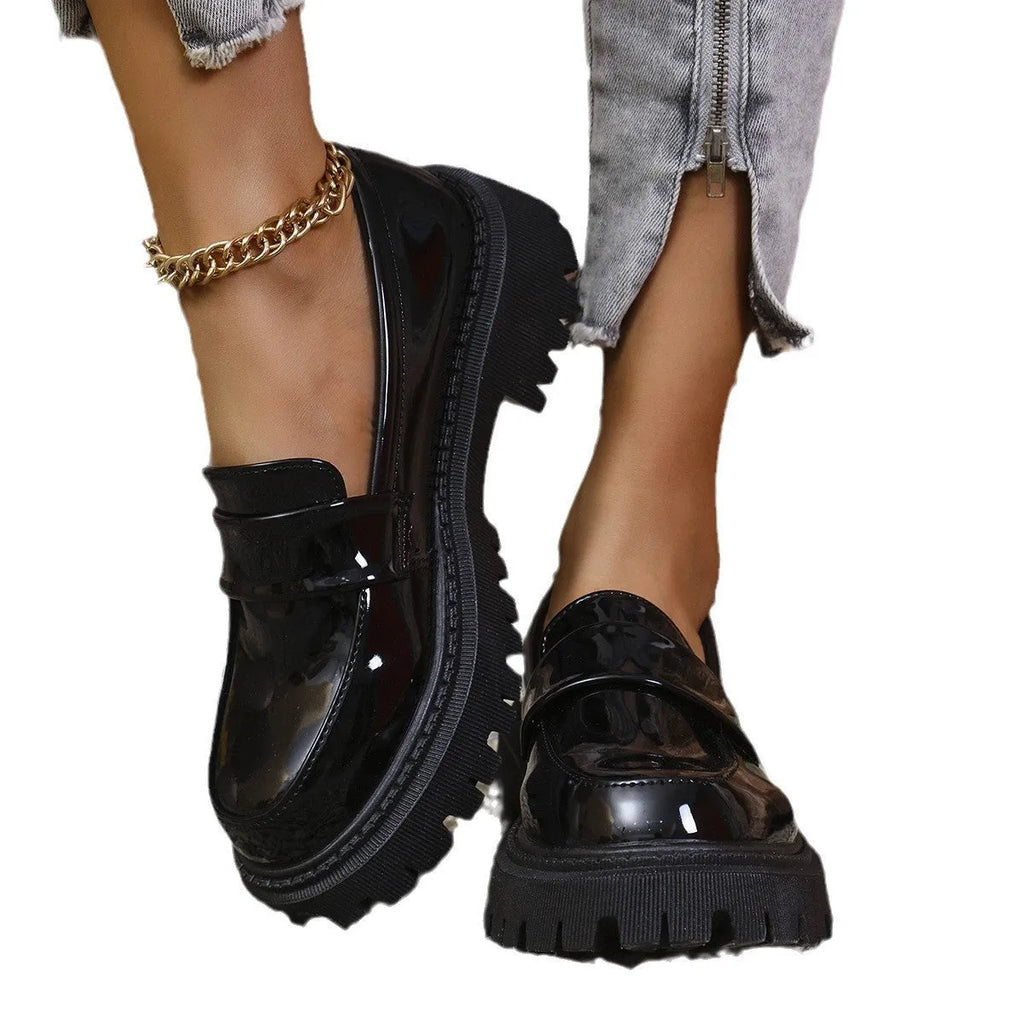 Women's black slip-on loafers with a chunky platform heel and rubber sole.