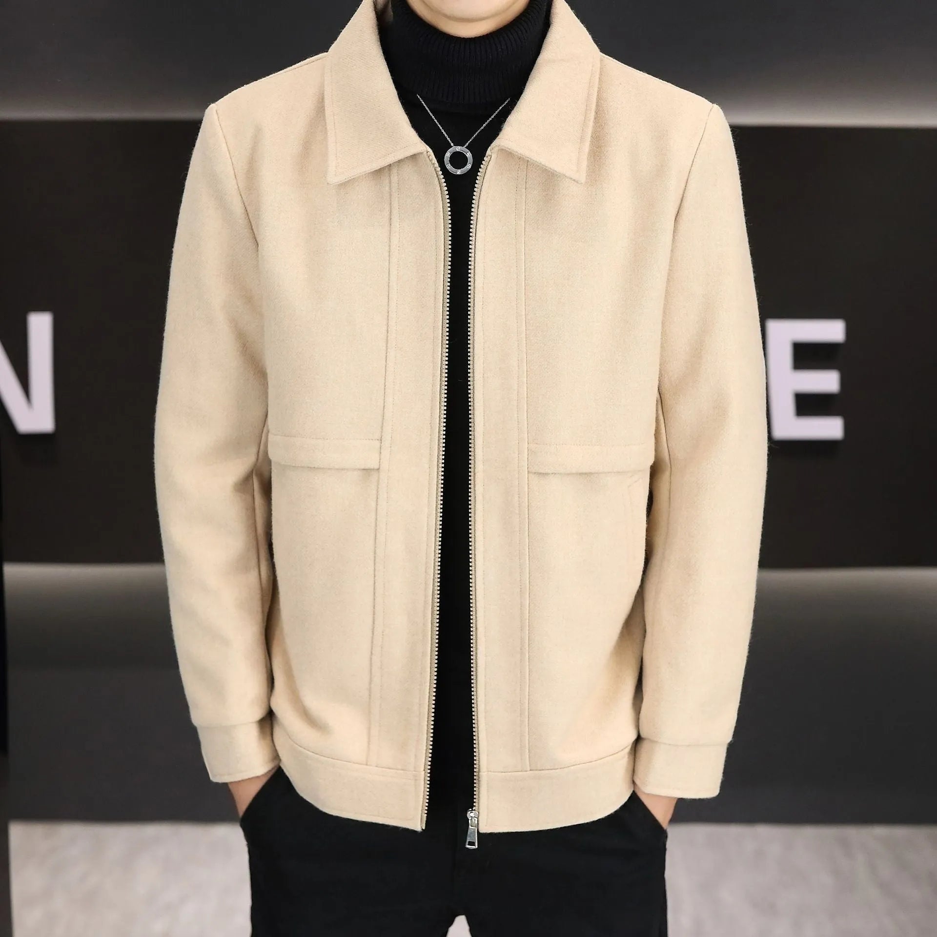 Man wearing a khaki polo collar casual jacket with side seam pockets.