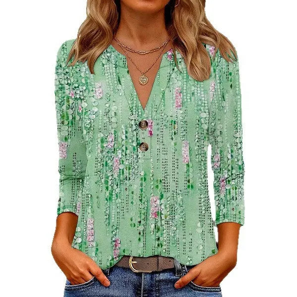 Women's loose fit V-neck top with a colourful 3D effect pattern, shown in a casual setting.