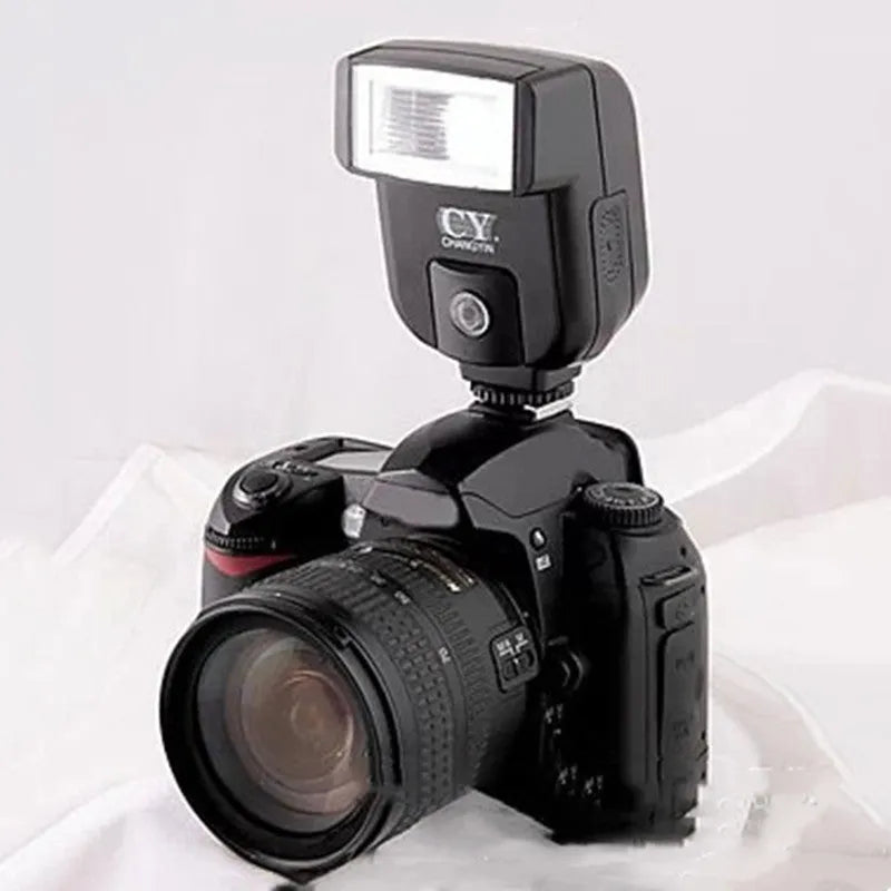 Compact silver hot shoe flash for SLR cameras with tilted head on a white background.