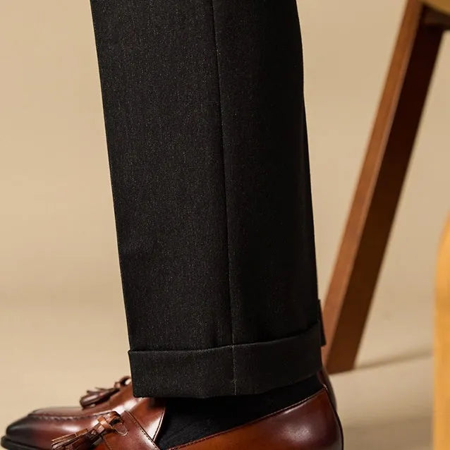 Men's black and brown genuine leather tassel loafers on a white background.