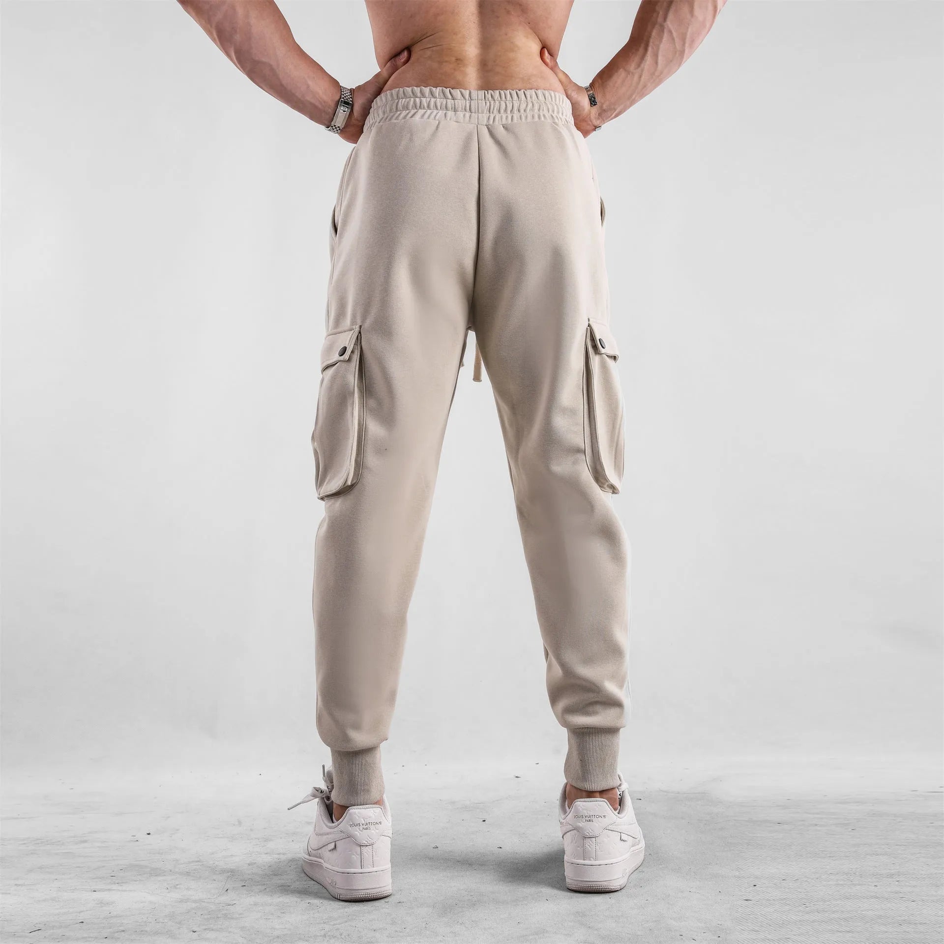 Men's loose cotton trousers with ankle ties and multiple pockets in a light grey colour