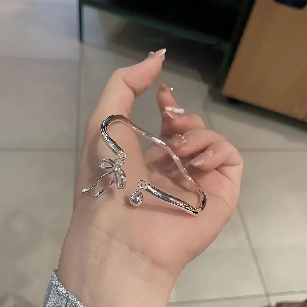 Silver adjustable bracelet with bow decoration and bell opening clasp on zinc alloy chain