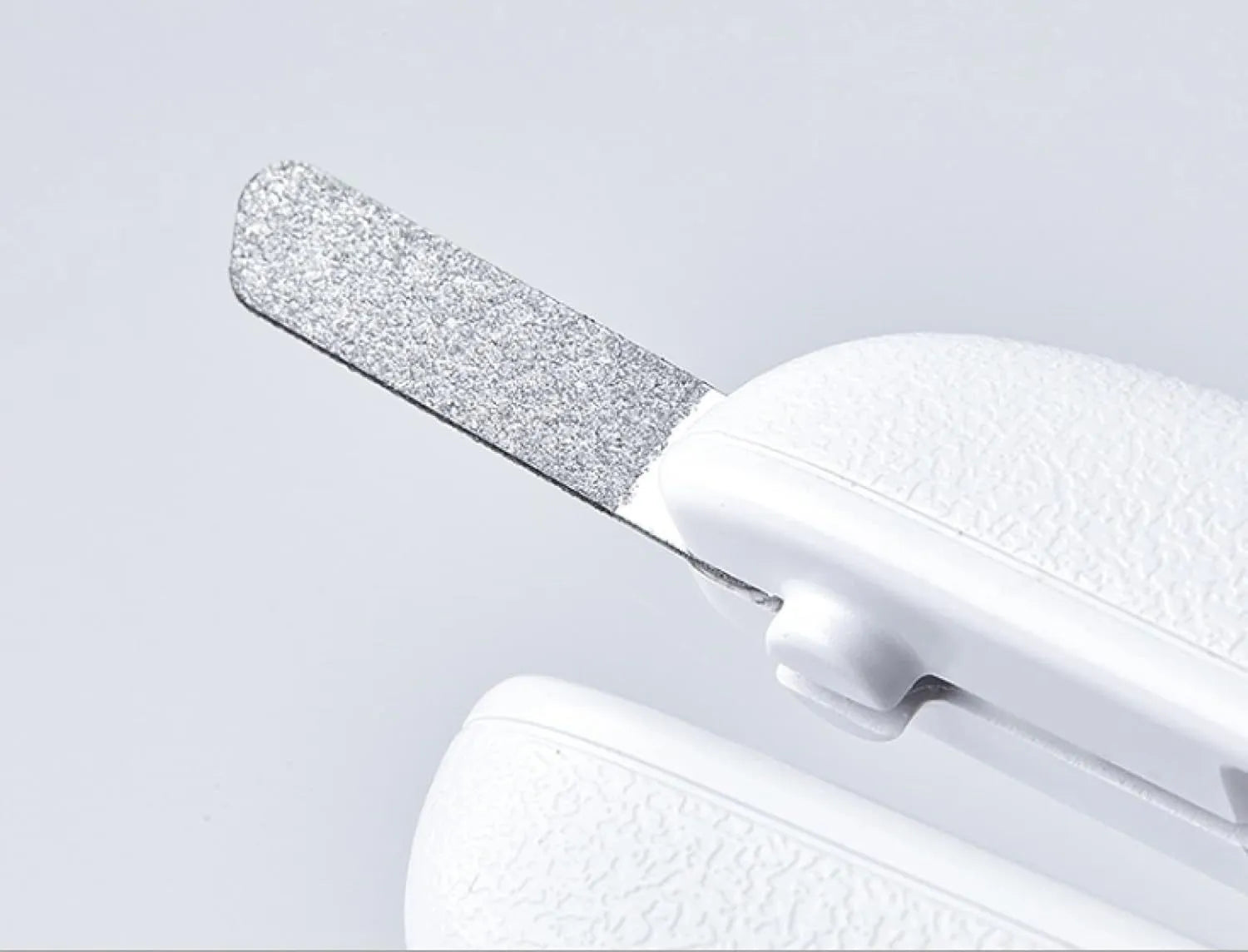 White pet nail clippers with LED light, transparent anti-splash guard, and integrated nail file on a grey background.