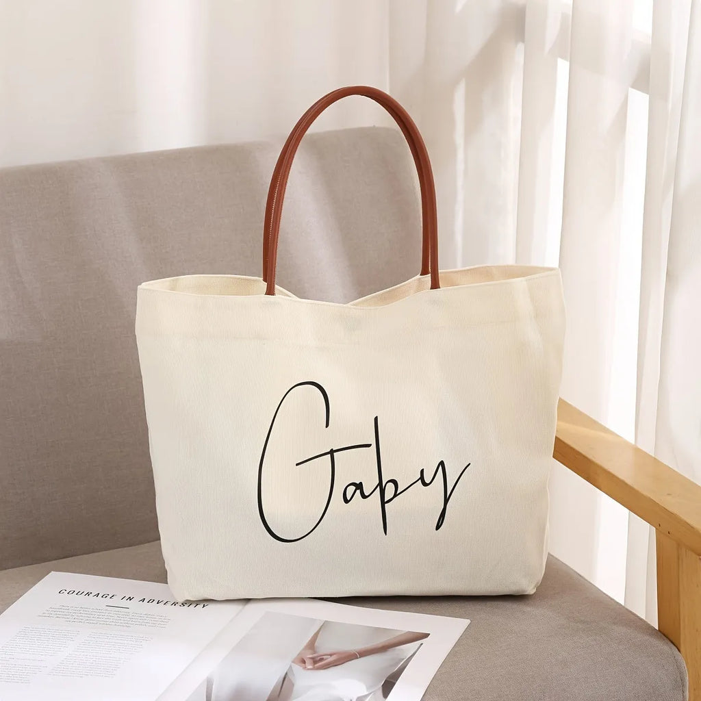 Beige white canvas tote bag with shoulder straps and front slip pockets