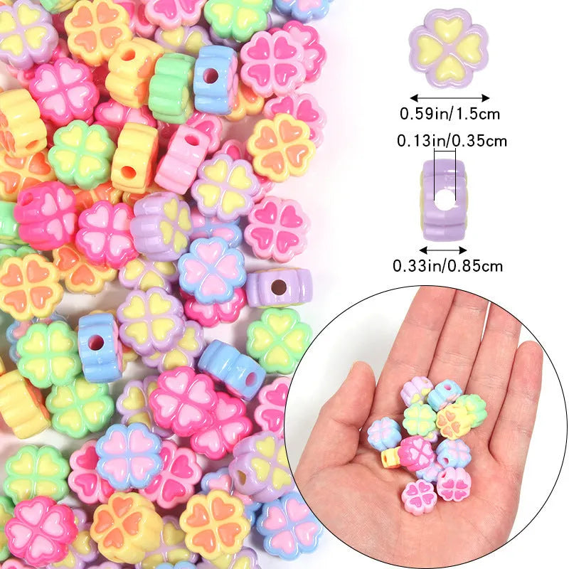Assortment of frosted acrylic love clover beads in mixed colours on a white background.