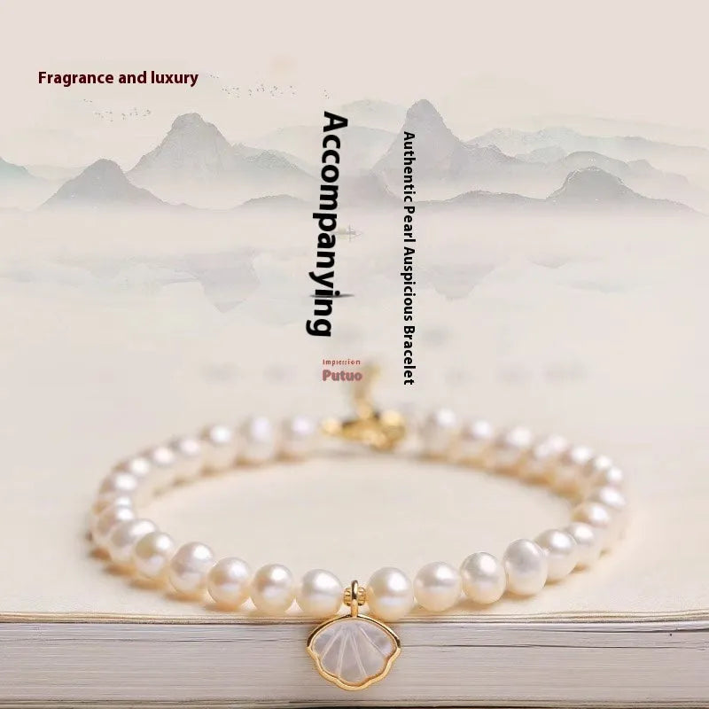 Women's fan-shaped freshwater pearl bracelet on wrist showing elastic string and extension chain options