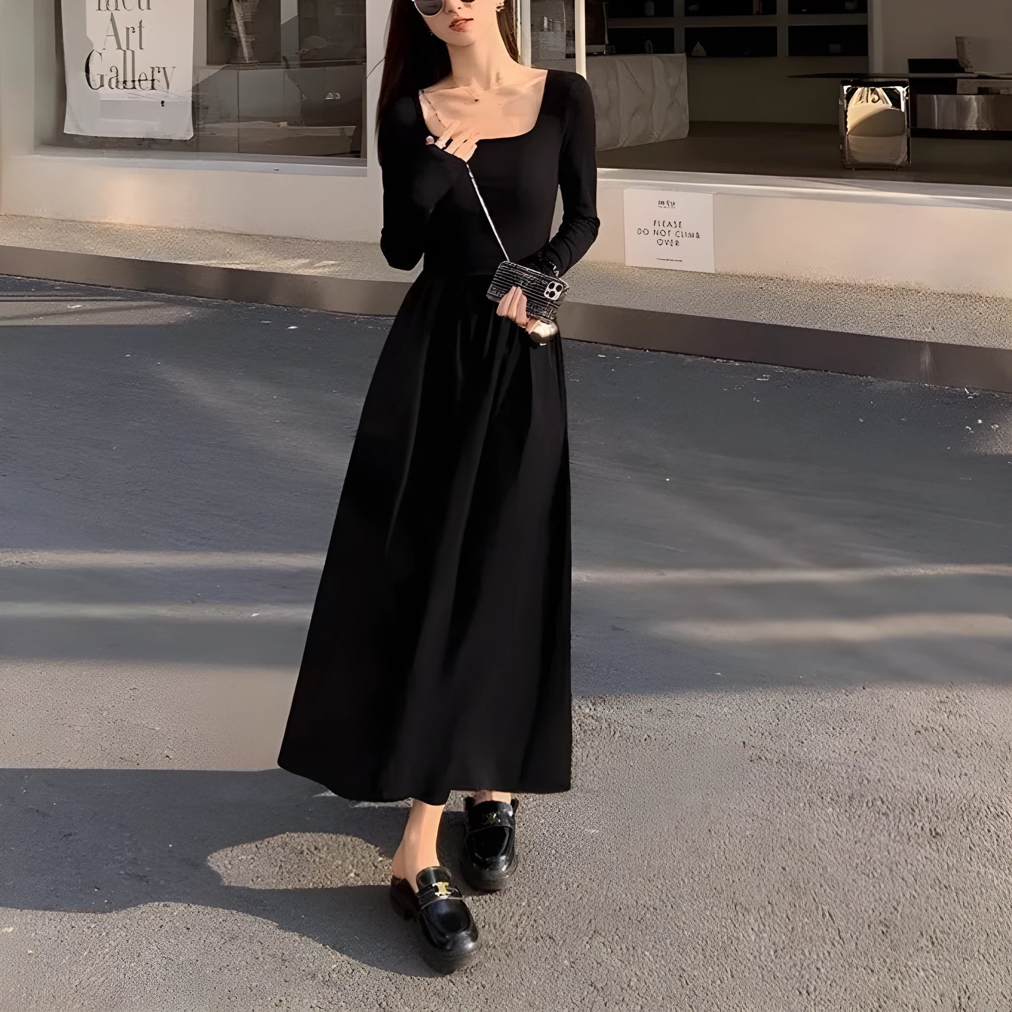 Women's black knitted A-line dress with square collar and long sleeves on hanger
