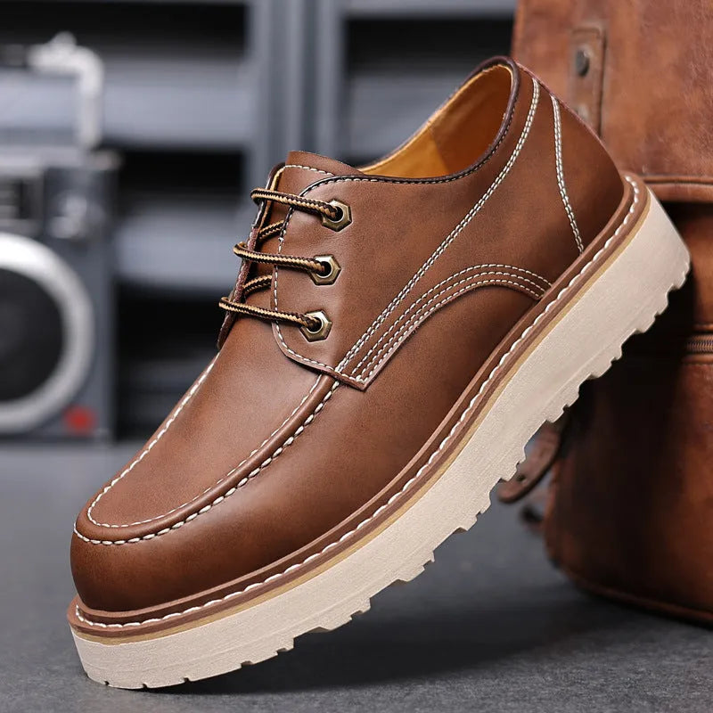 Men's black retro low-top Martin boots with a rounded toe and rubber sole on a plain background.