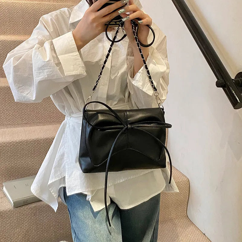 A black horizontal square underarm crossbody bag with large capacity and visible sewing lines.