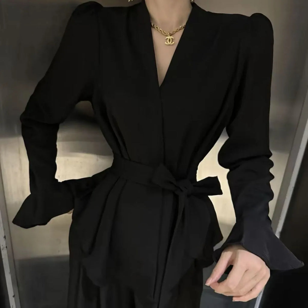 Women's black French-style shirt with an irregular collar, long flared bell sleeves, and a tied front closure.