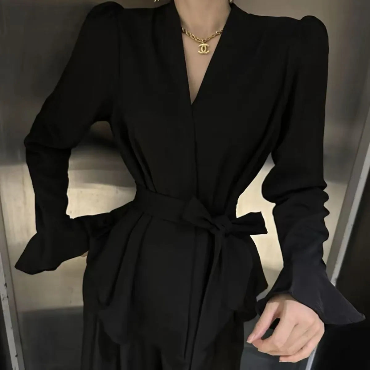 Women's black French-style shirt with an irregular collar, long flared bell sleeves, and a tied front closure.