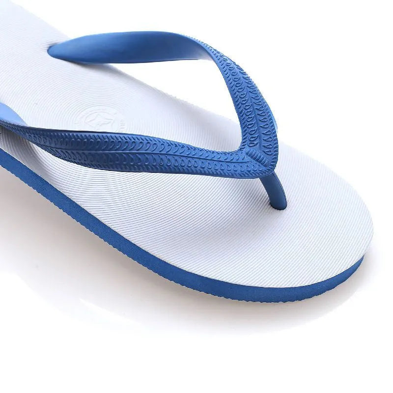 Rubber beach flip-flops in black with a white fish label on the strap, showing non-slip tread pattern.