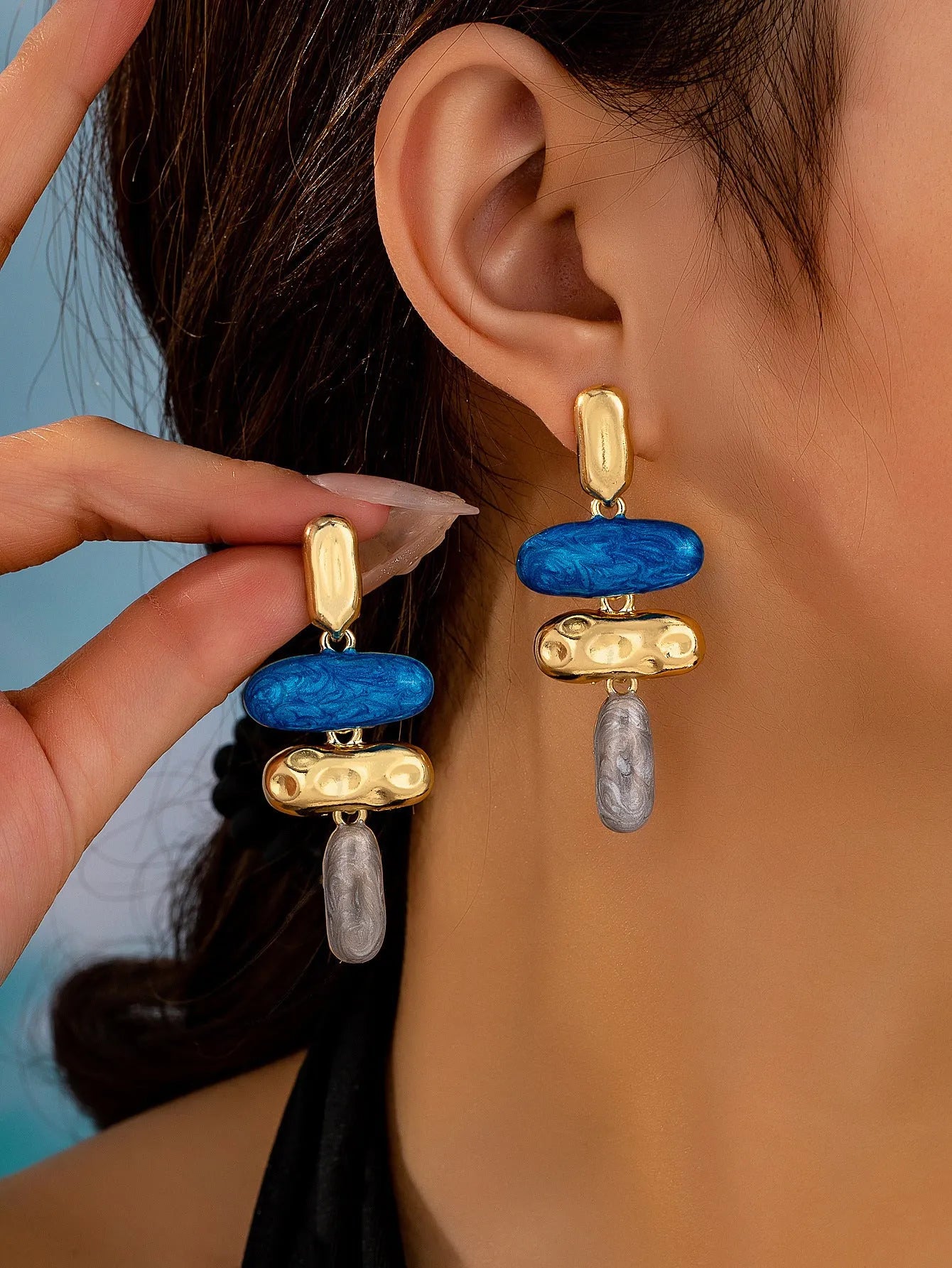 A pair of geometric stud earrings with a multicolour electroplated finish on a zinc alloy base.