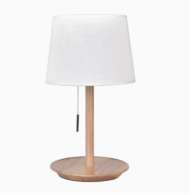Walnut colour solid wood table lamp with a white cloth shade and a black cable switch