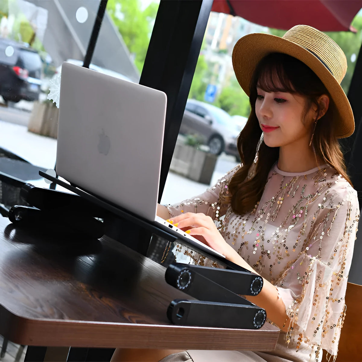 Black folding computer desk with adjustable strap and cooling holes for laptop ventilation