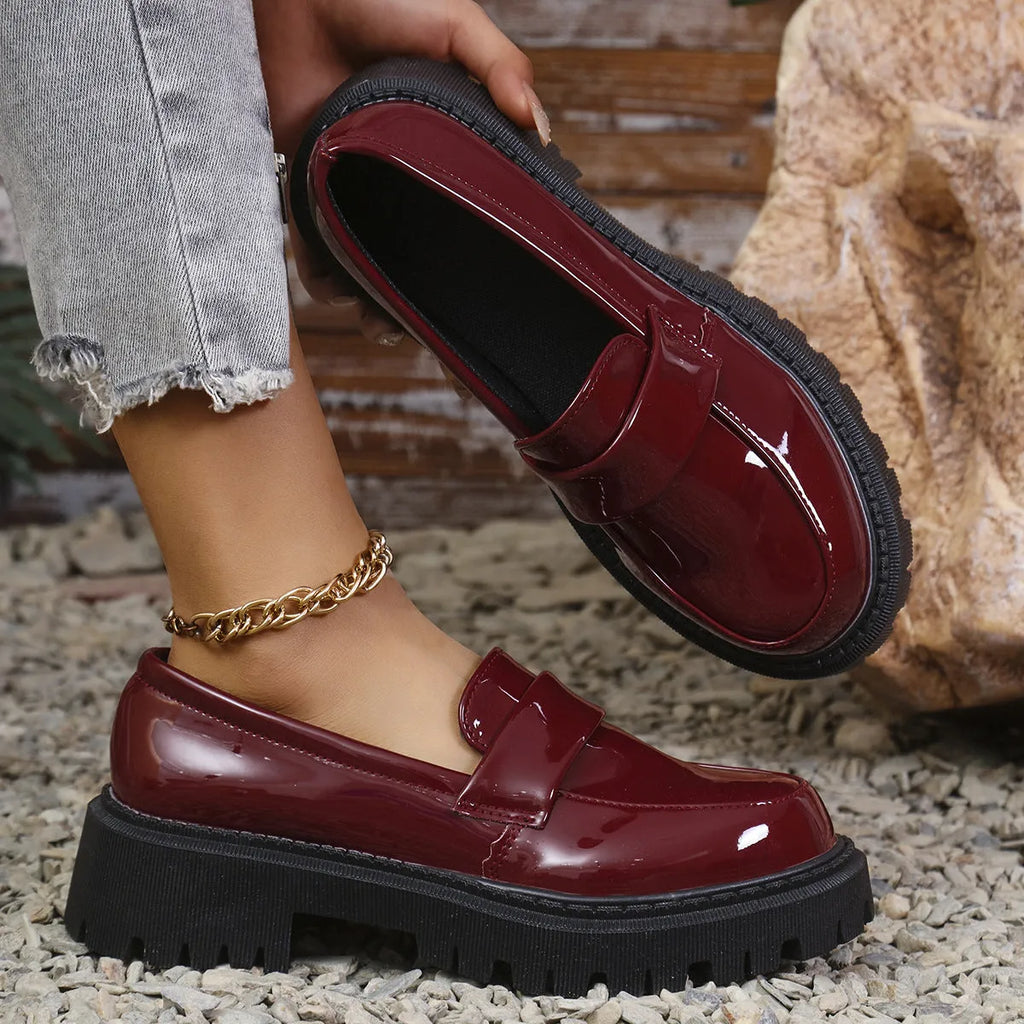 Women's black slip-on loafers with a chunky platform heel and rubber sole.