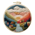 DIY landscape embroidery kit with bamboo frame, printed fabric, and thread on a table