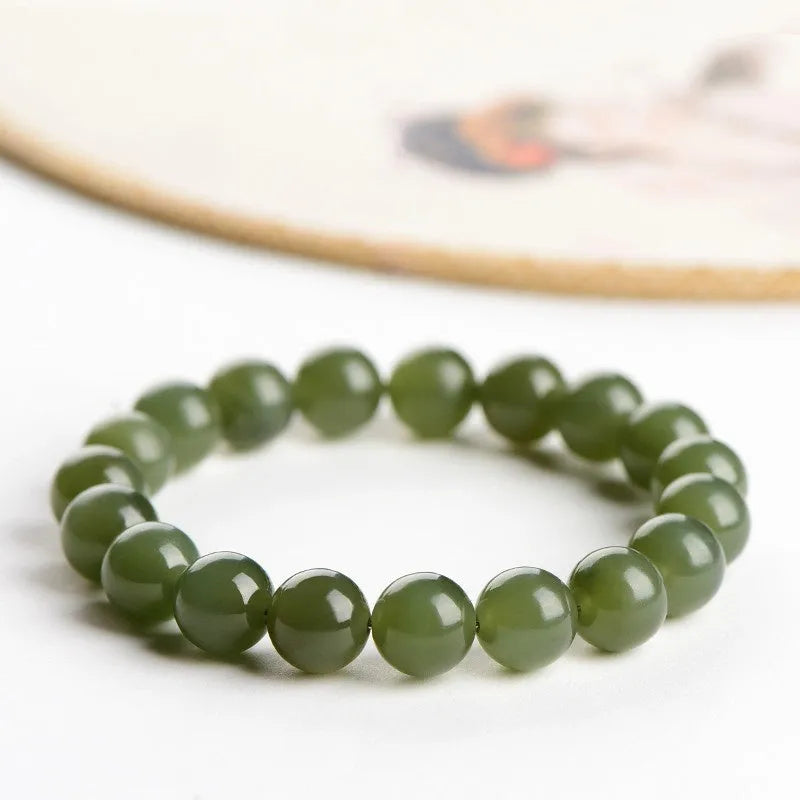 Polished Hetian jade ball bracelet in ice-like clear colour on a white background.