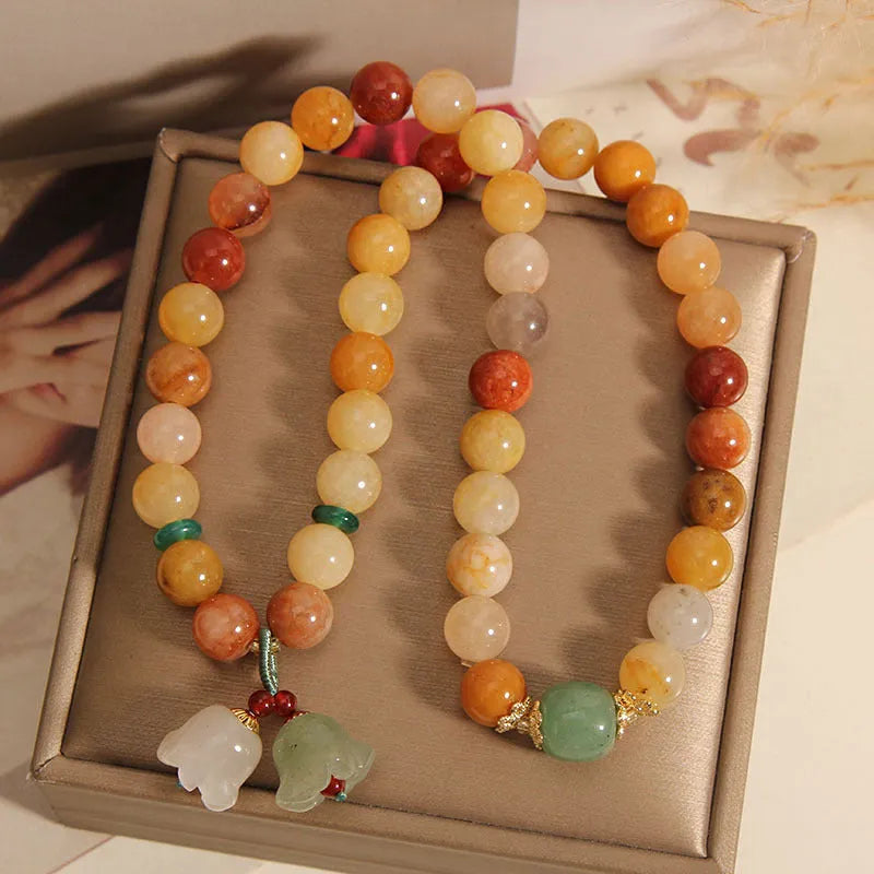 Dark green natural jinsi jade multi-layer bracelet with orchid pendant and adjustable sliding knot clasp.