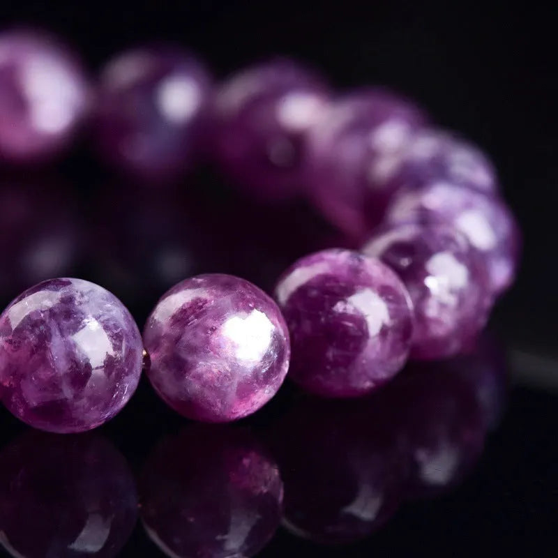 Grandmother Crystal Bracelet with polished purple beads in geometric shapes on a wrist.