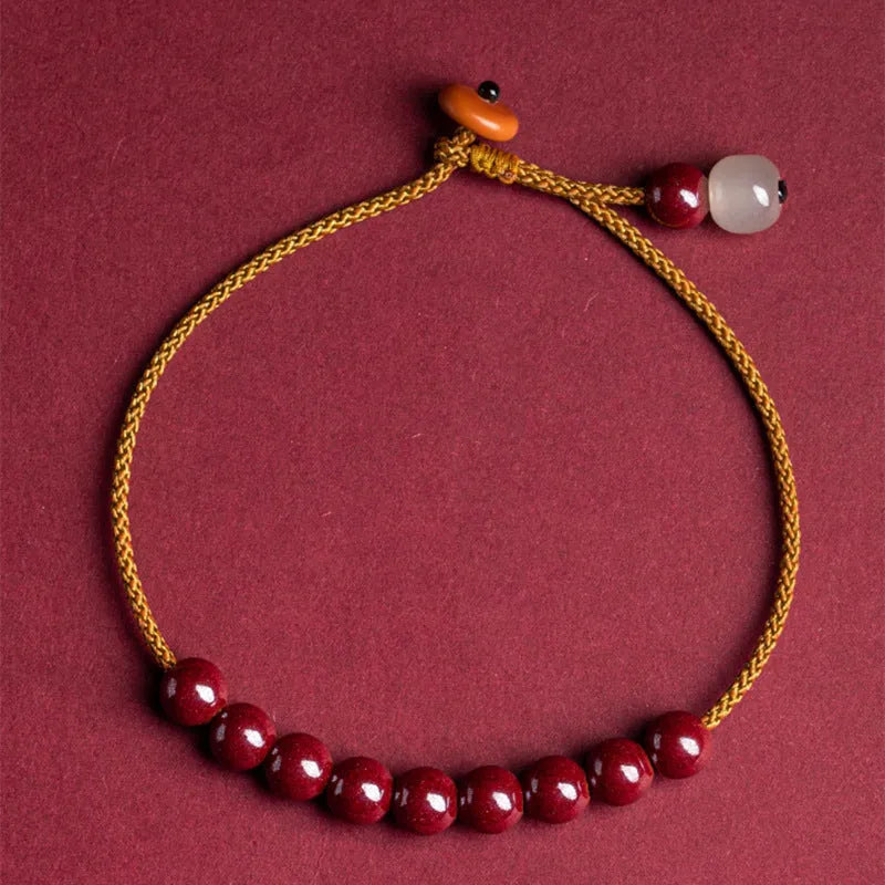 Hand-woven raw cinnabar bracelet with geometric shape on model wrist.