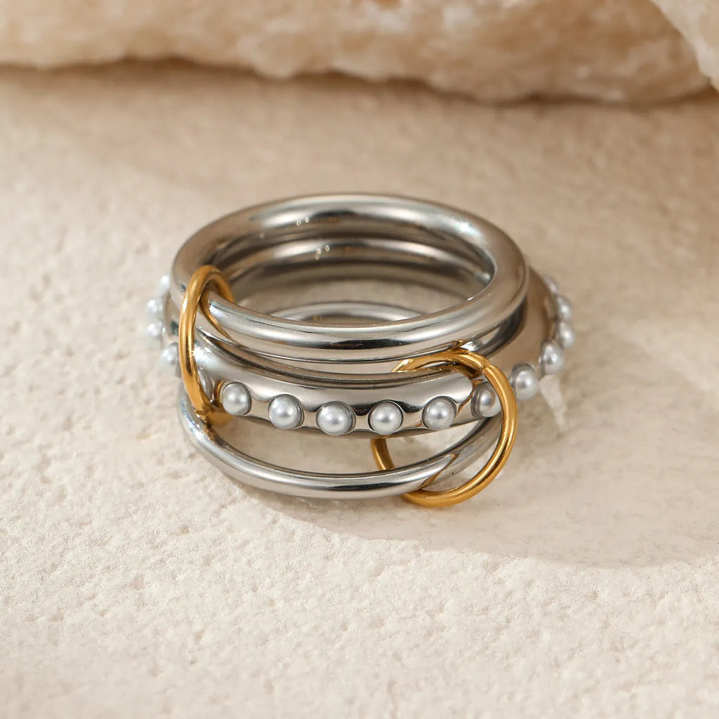 Stacked gold-plated stainless steel rings for women in three colour options, shown as a layered set on a hand.