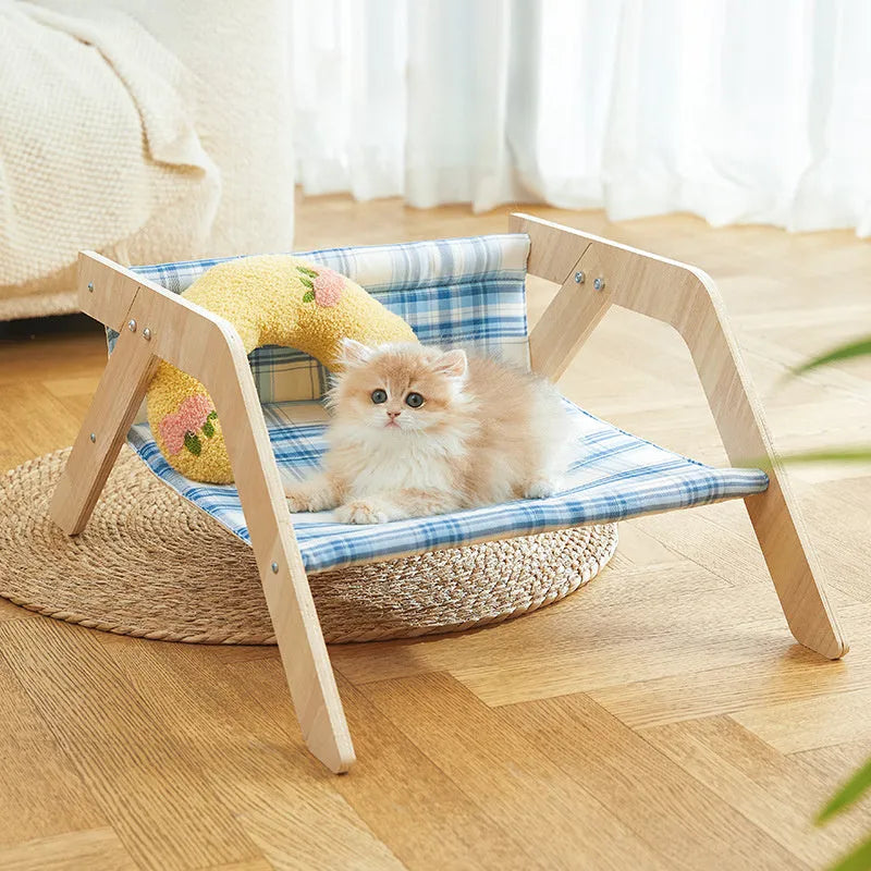 Wooden framed elevated cat bed with blue cloth hammock in beach chair style.