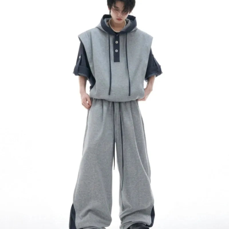 Men's black heavy industry sports suit with hooded short sleeve jacket and trousers laid flat.