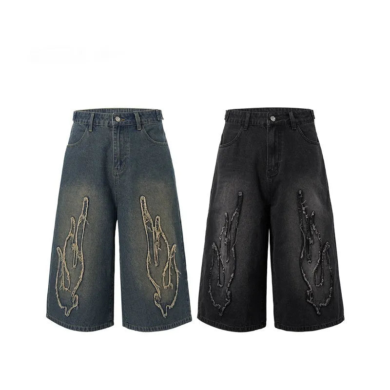 Men's black cropped denim shorts with flame embroidery patch detail on straight leg silhouette