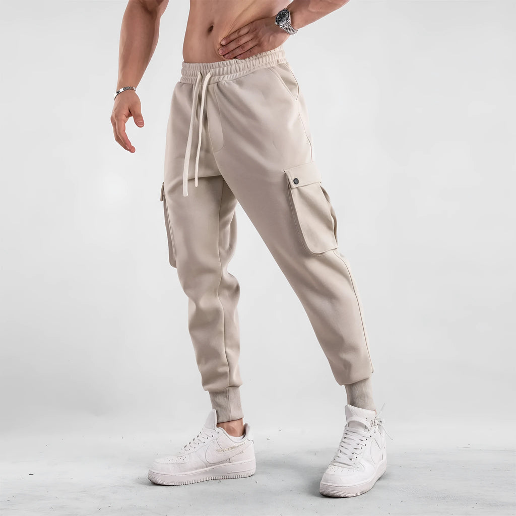 Men's loose cotton trousers with ankle ties and multiple pockets in a light grey colour