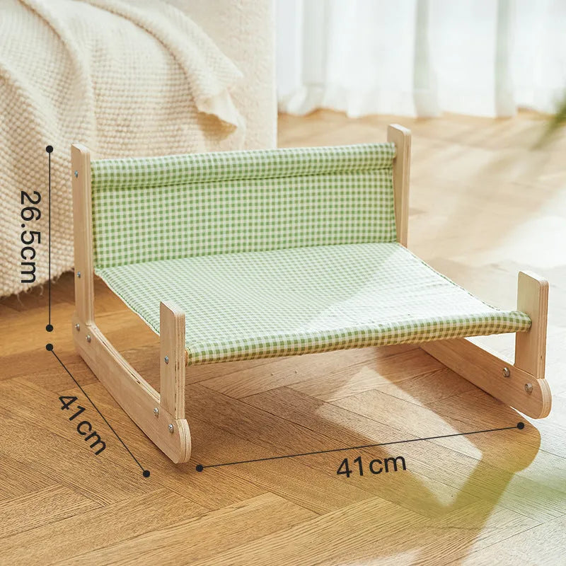 Wooden framed elevated cat bed with blue cloth hammock in beach chair style.